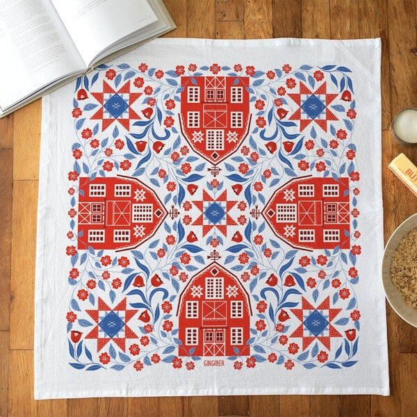 Decorative tea towel with red and blue pattern on a wooden surface