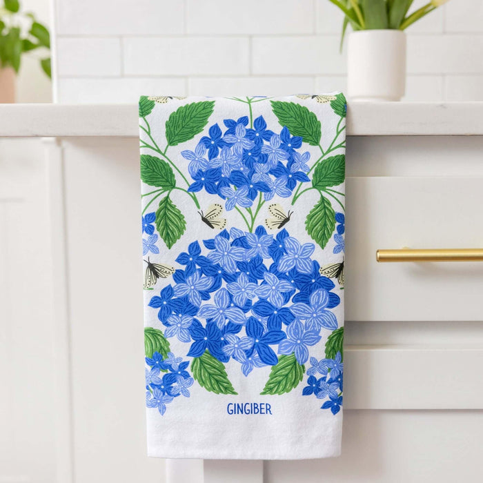 Towel with blue floral design hanging on a white cabinet.