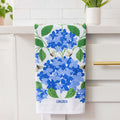 Towel with blue floral design hanging on a white cabinet.