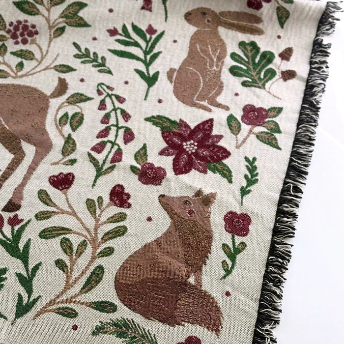 Blanket - woven throw featuring winter and forest animal illustrations on light background