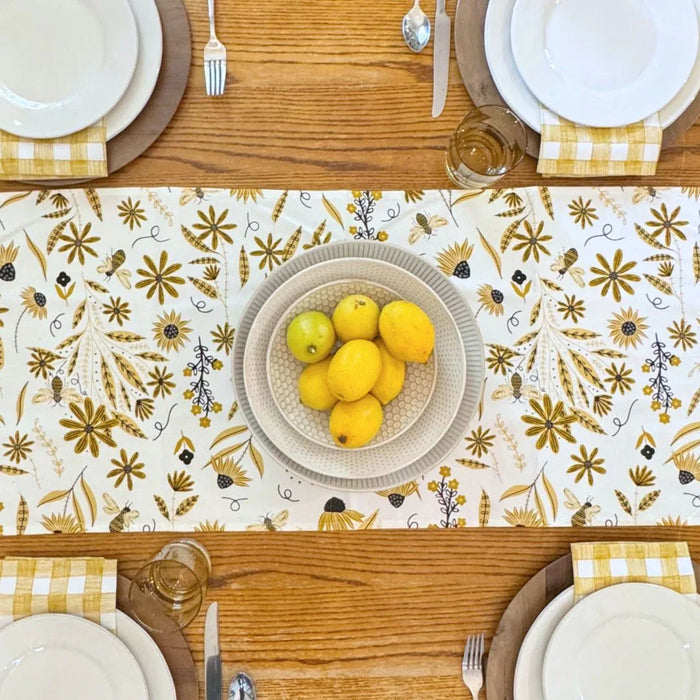 bundle of tabletop products - white table runner with bee and floral elements, gold gingham cloth napkins