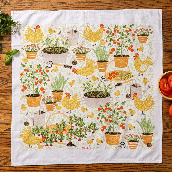 tea towel with illustrated vegetables, chickens, and garden details