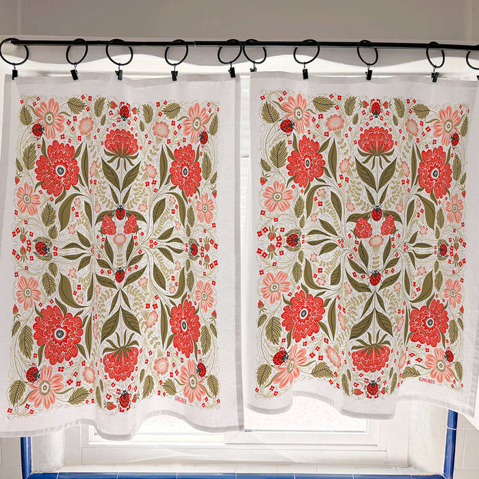 Floral patterned curtains hanging on a rod with a tiled wall background.