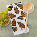 Butterfly-patterned towel with wooden spoon and bowl on a green surface