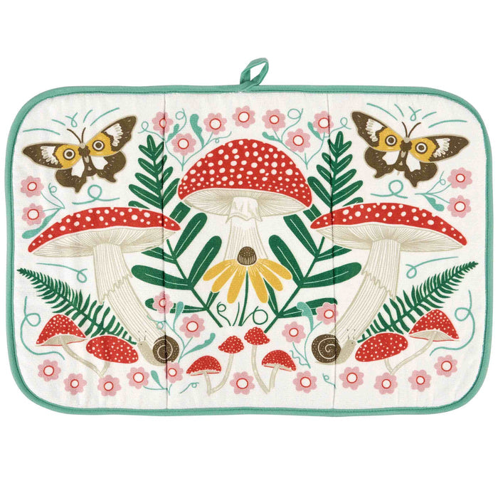 A square quilted potholder with a colorful woodland design featuring red and white mushrooms, green ferns, pink flowers, yellow flowers, and butterflies on an off-white background, finished with a mint green border and top loop.