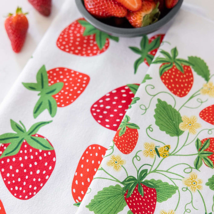 Strawberry-patterned fabric with a bowl of strawberries on a white background
