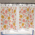 Floral patterned curtains hanging on a rod with a window in the background.